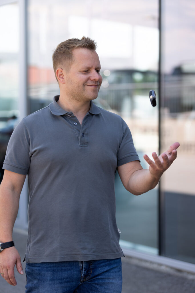 Person mit Autoschlüssel werfend, lacht zufrieden