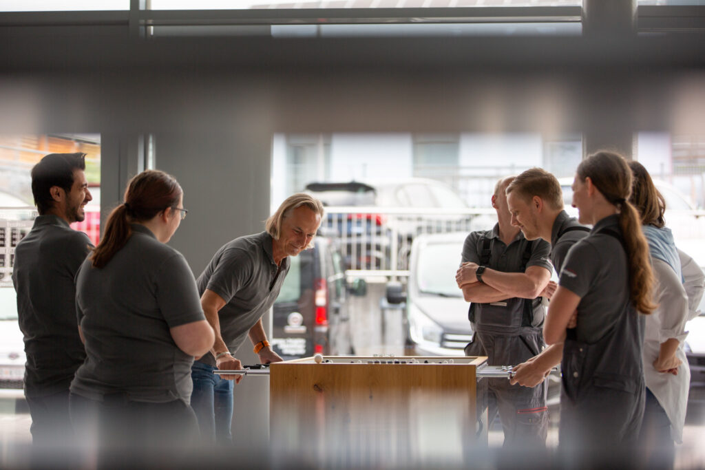 Mitarbeiter Mitarbeiterinnen beim Tischfussball spielen Firma Automobile Deschberger in Hannesgrub Tumeltsham