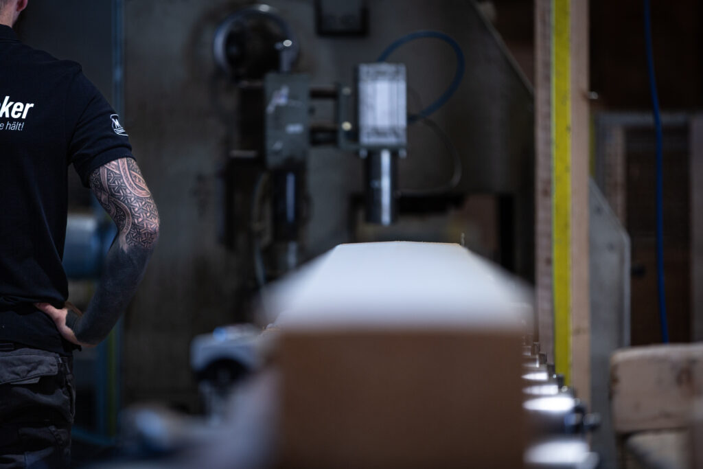 Person an der Maschine in der Holz Verarbeitung, Tattoos am Arm