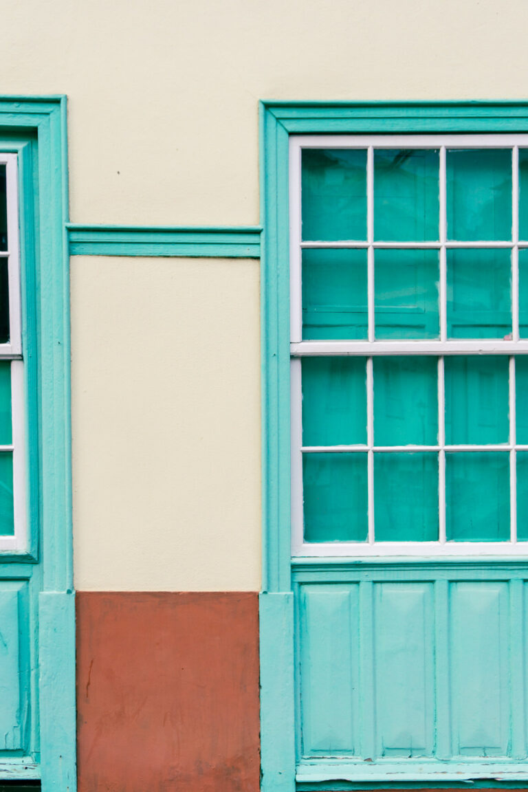 La Gomera mintgrüne Türen mit weißem Rand beig-rote Hausmauer schiefe Winkel