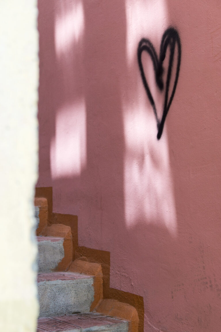 La Gomera gemauerte Stiege Blick in die Gasse rosefarbene Wand schwarz gespraytes Herz an der Wand