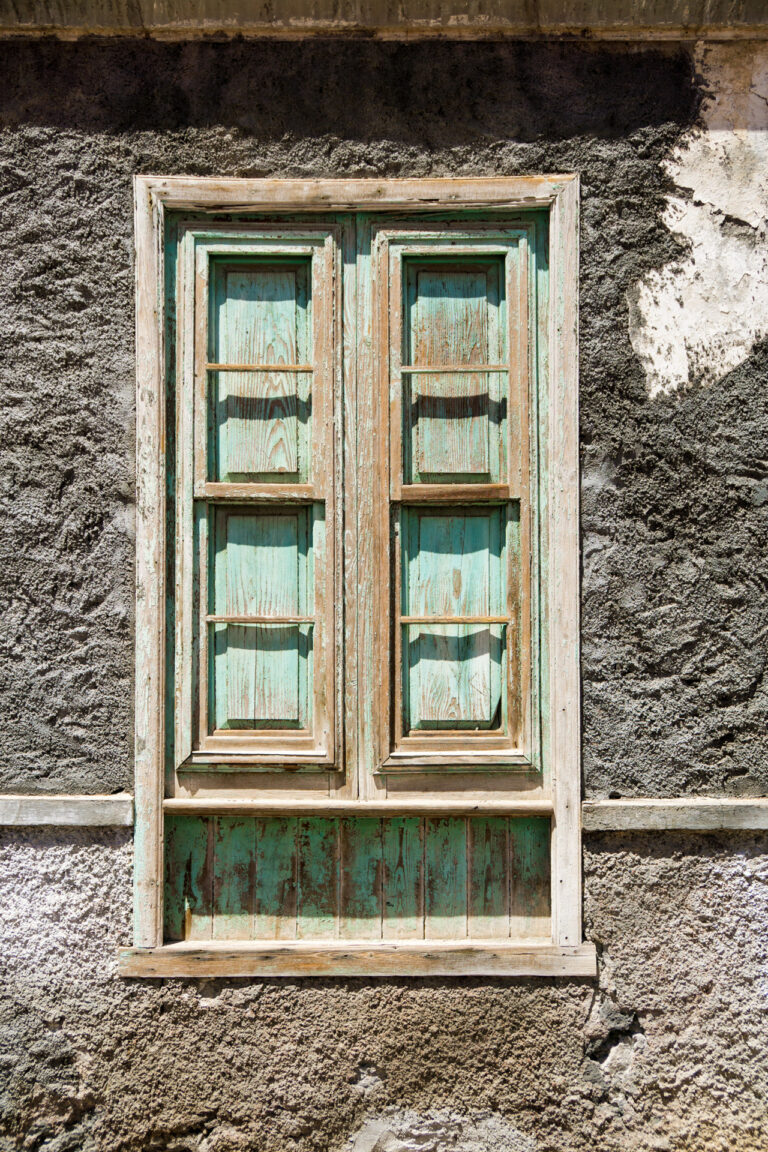 La Gomera raue bröckelige Fassade Holzfensterrahmen mit mintfarbenem fleckigen Muster