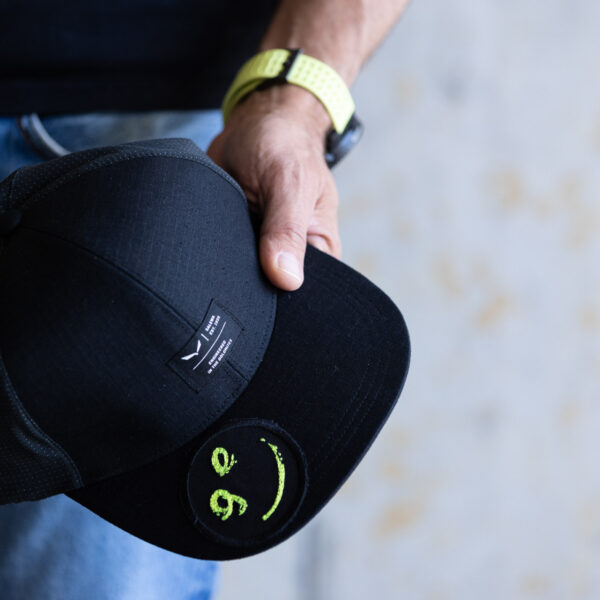 Georg hält Kappe mit Logosmiley in der Hand