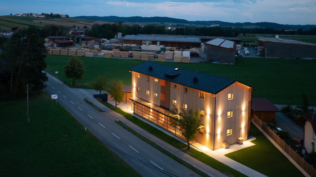 Drohnenansicht in der Dämmerung des beleuchteten Holz Wohnbaus