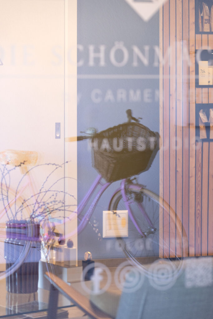 Spiegelung im Schaufenster rosa Rad von Carmen Die Schönmacherei by Carmen Greil, Hautstudio @getifo.com