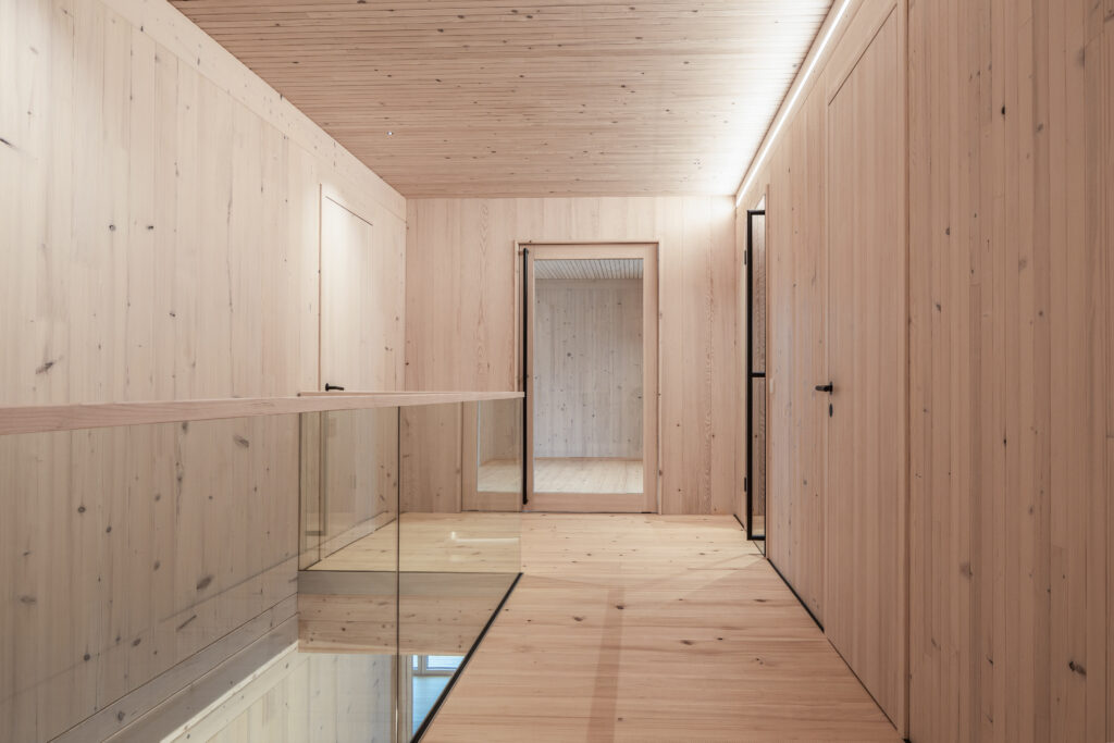 Gang in Holz und Glas im oberen Stockwerk Wohnhaus Holzbauweise